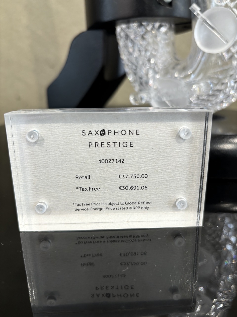 Price sticker for a crystal saxophone where misspelled "saxaphone" has incorrect letter scribbled out.